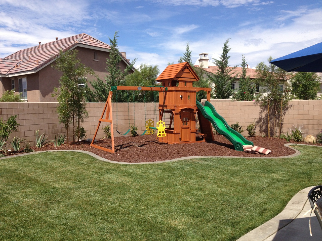 Playset for children in a fenced in backyard.