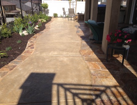 Colored concrete with flagstone border Oval fire pit with sitting wall and colored concrete in Temecula McCabe's Landscape Construction