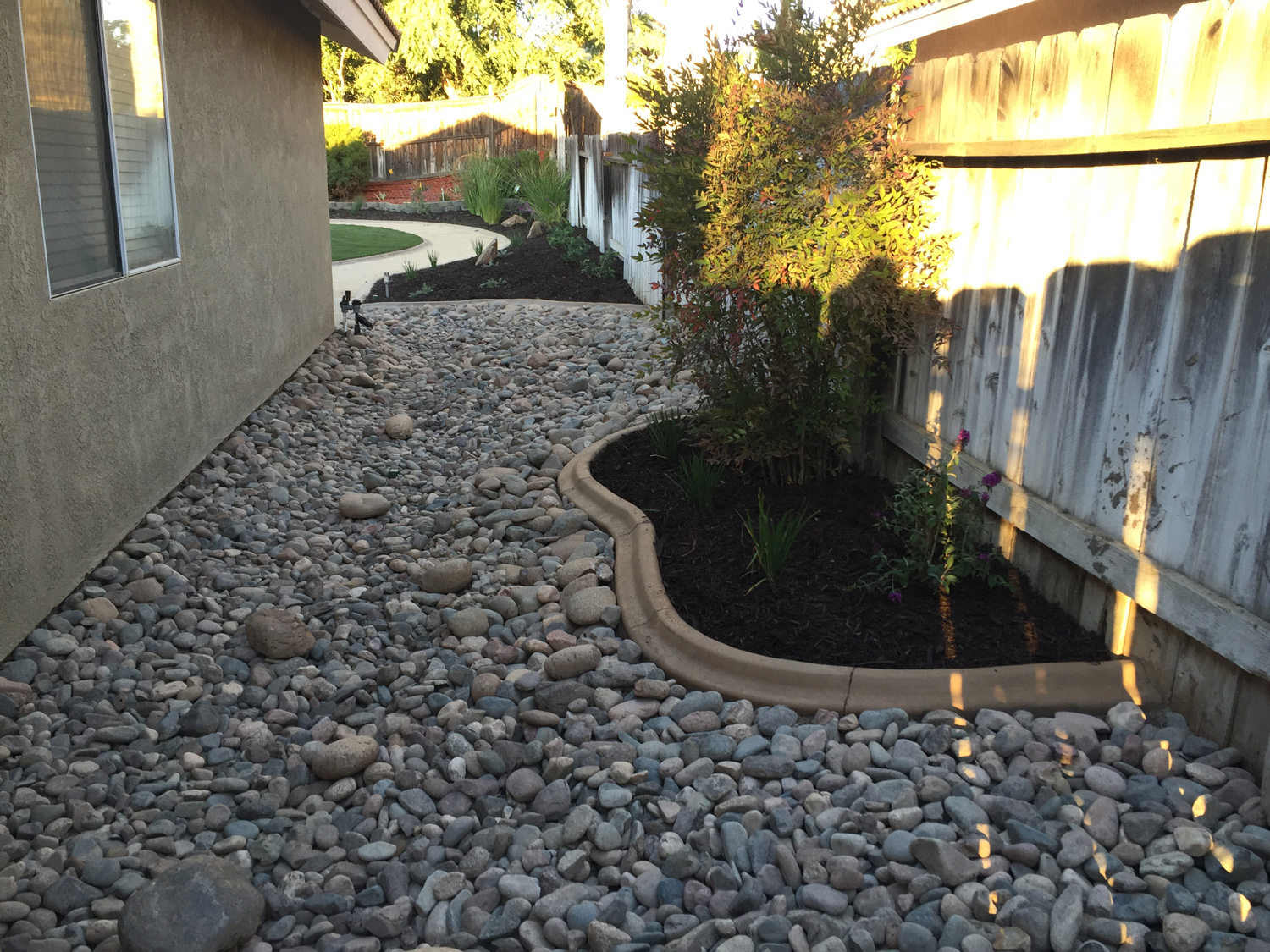 Rock bed and mulch bed on the side of the house.