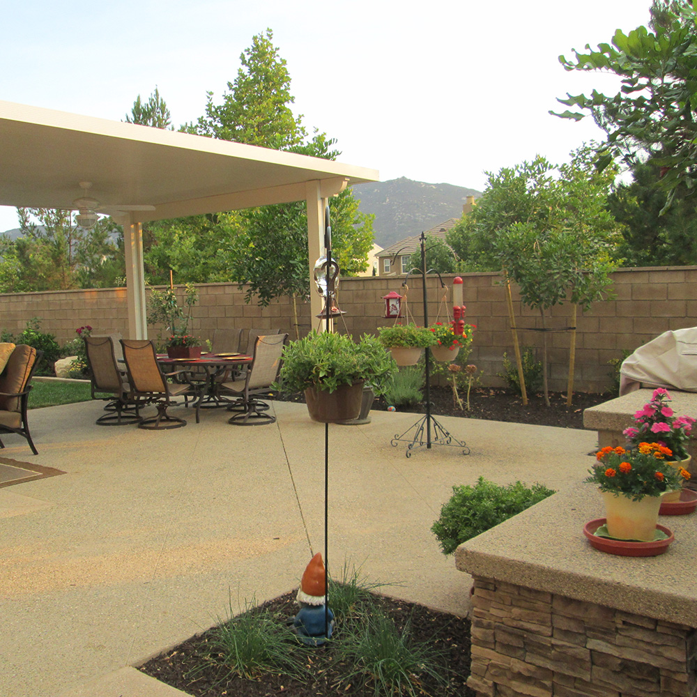 Exposed aggregate concrete in the color tan with Alumawood patio cover and BBQ.