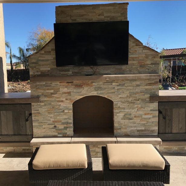 Outdoor fireplace with TV set and storage cabinets