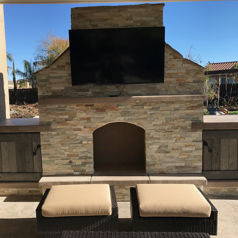 Outdoor fireplace with TV set and storage cabinets