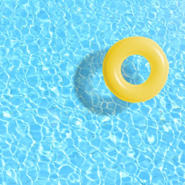 Yellow swimming pool ring float in blue water. concept color summer.