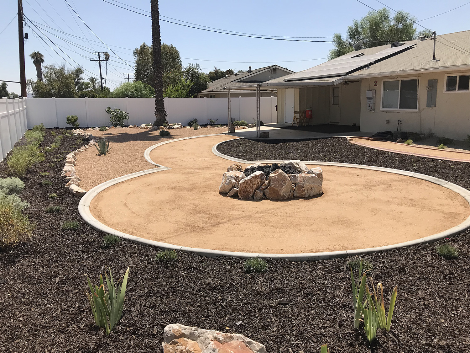 Low water backyard with boulder fire pit