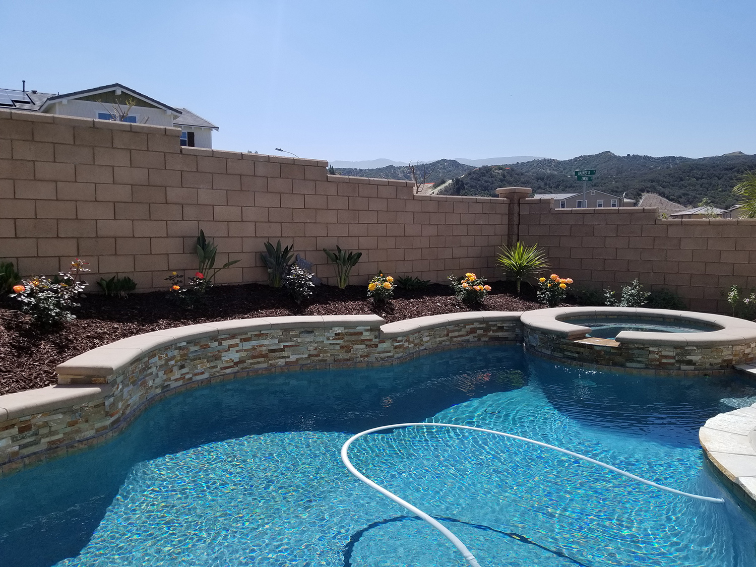 Pool with raised wall, stonework and plantings