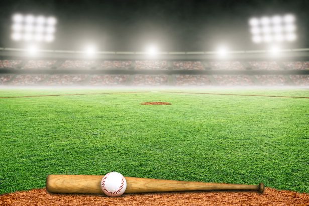 Baseball bat and ball on field at brightly lit outdoor stadium.