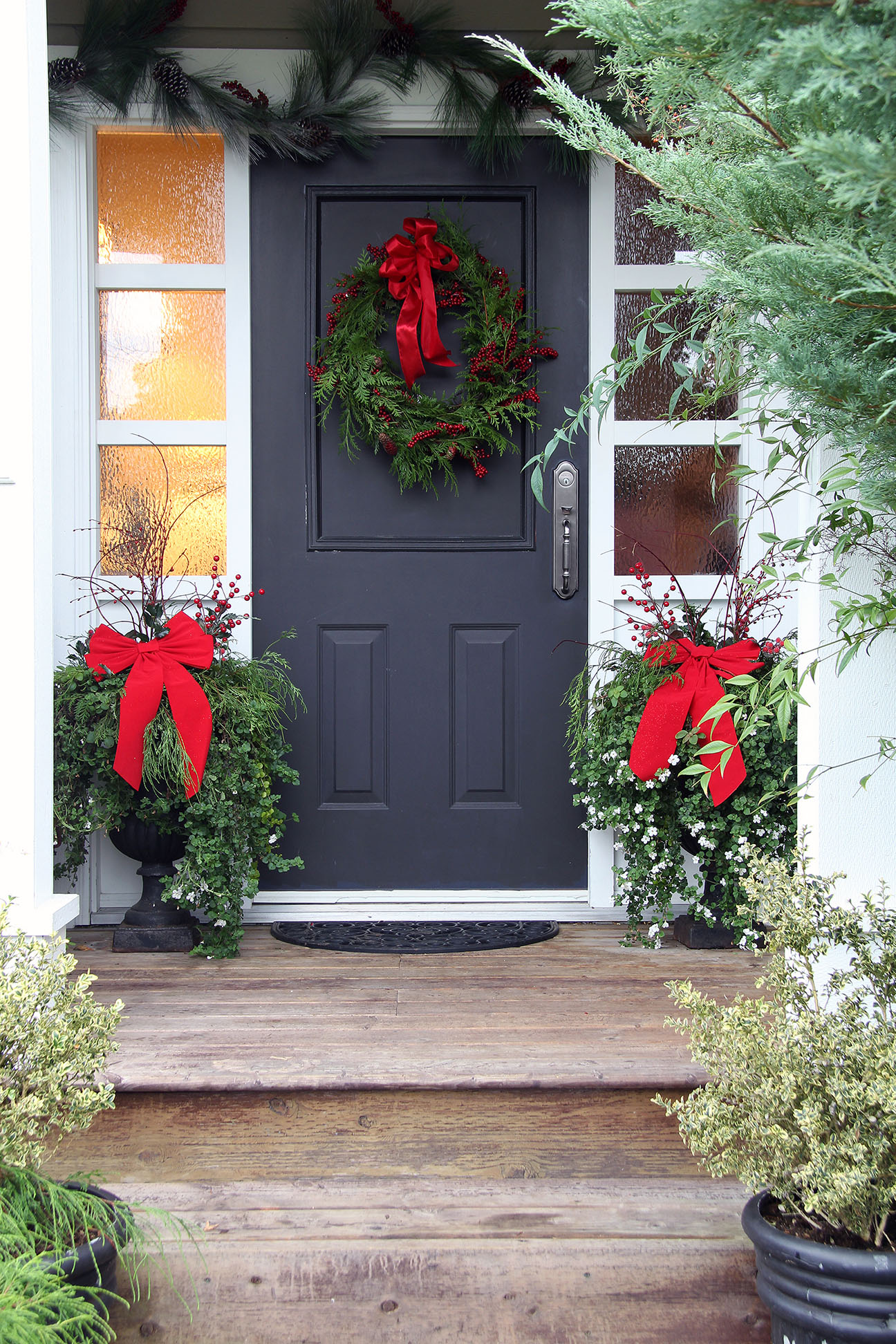 Front door with a Christmas wreath and bows.