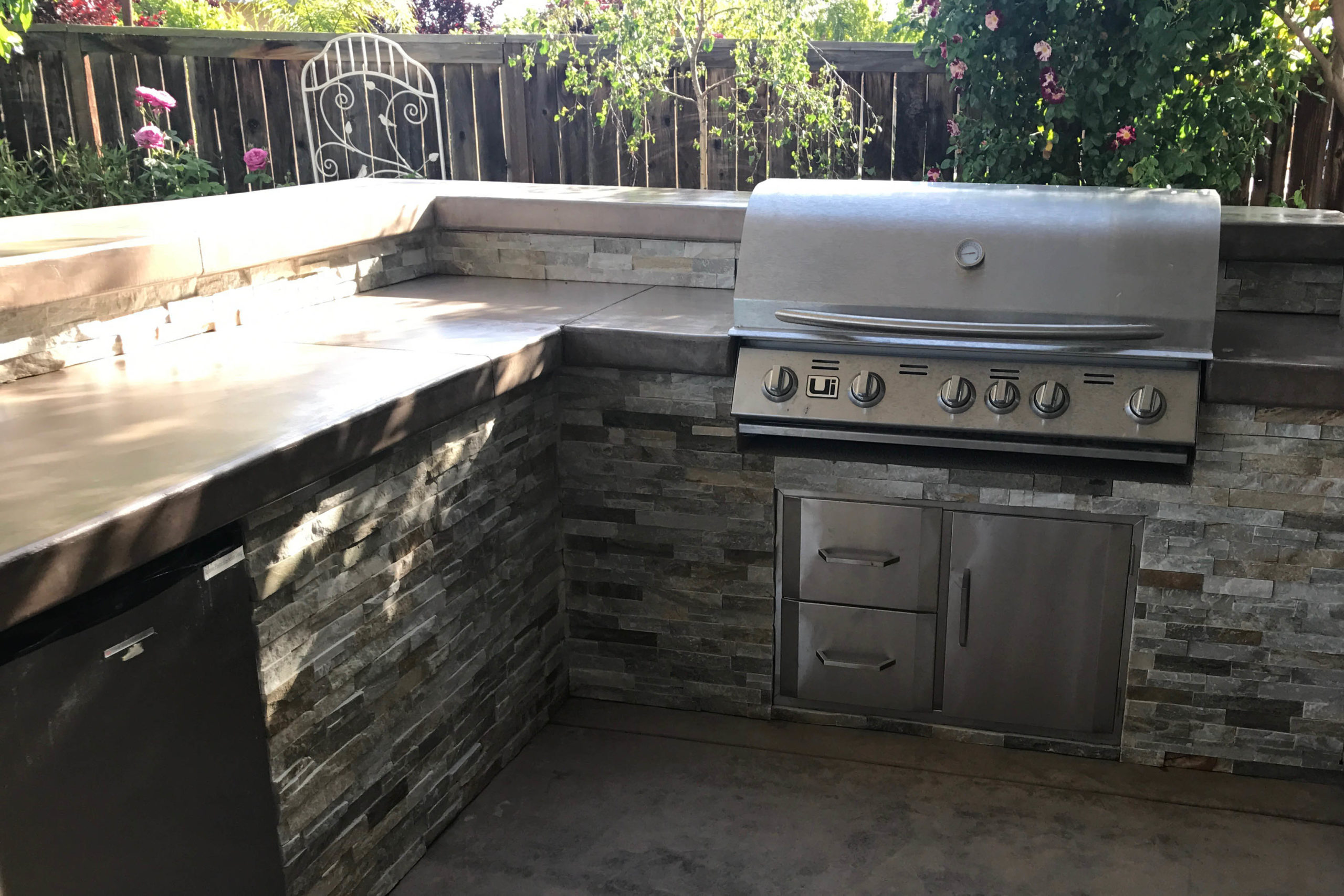 Outdoor kitchen BBQ island with quartz stone facing and concrete countertop
