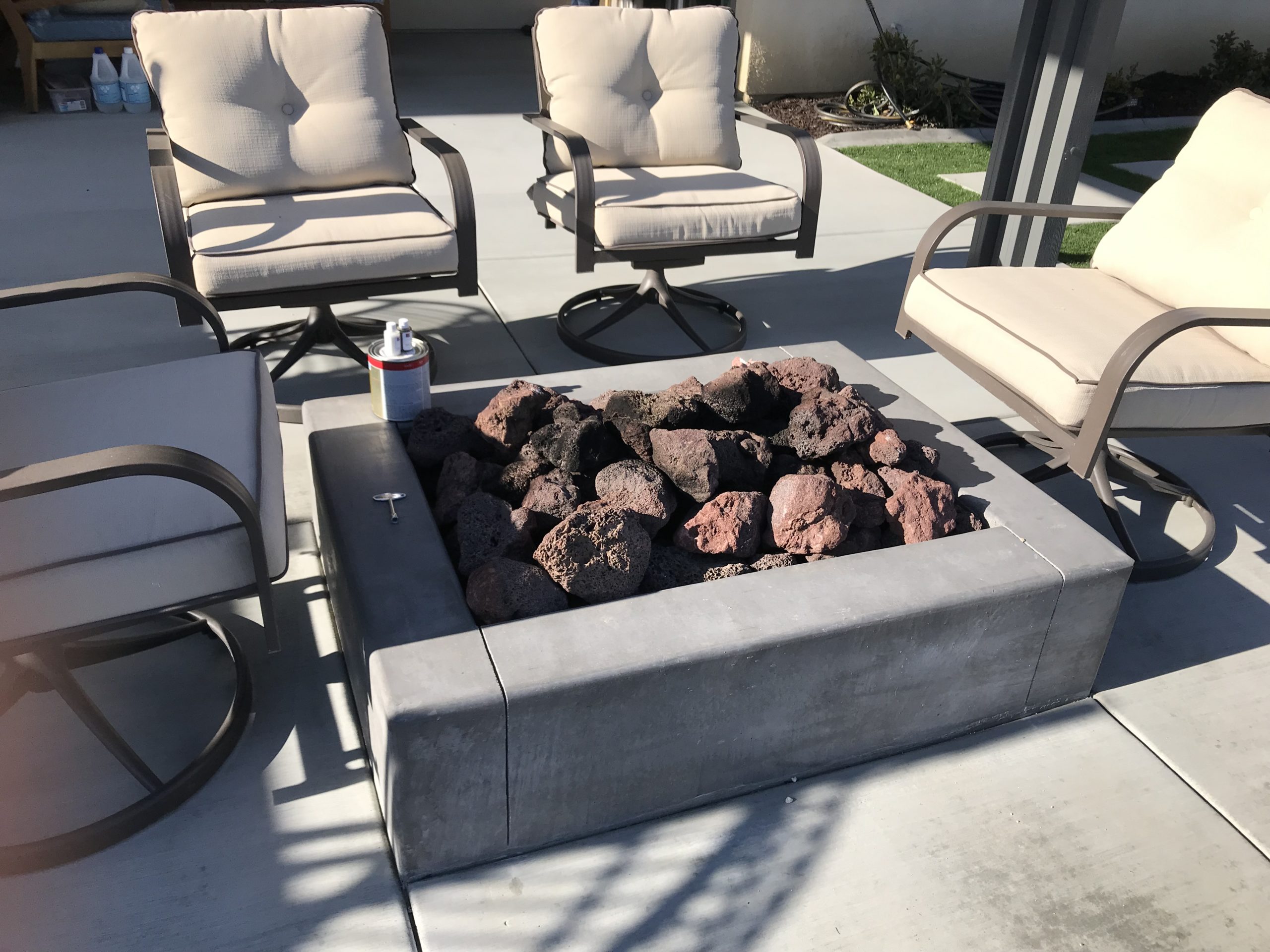 Custom fire pit surrounded by patio chairs.